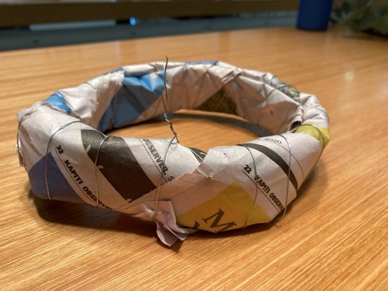 Paper formed into a ring with wire wrapped around to hold the shape.